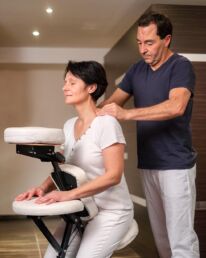 Eine Frau geniesst eine entspannende Chairmassage am Arbeitsplatz