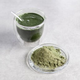 Gr&uuml;ner Smoothie mit Gerstengras in einer Glastasse